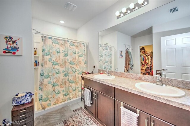 2733 Merida Ln, Cape Coral, FL 33909 - full bath featuring curtained shower, tile patterned floors, double vanity, and a sink