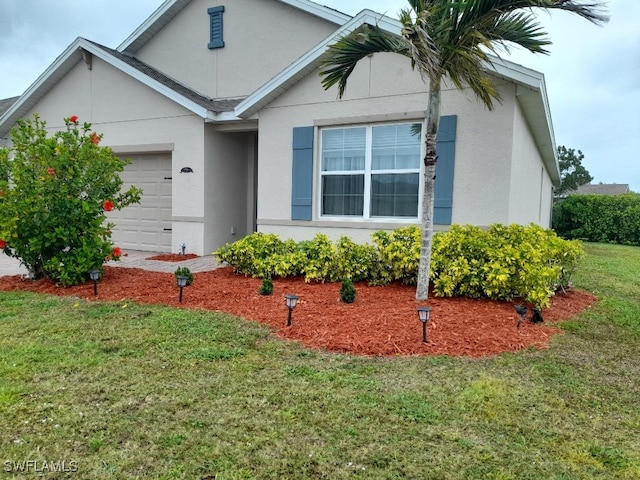 view of front of house featuring a front lawn, a garage, and stucco siding