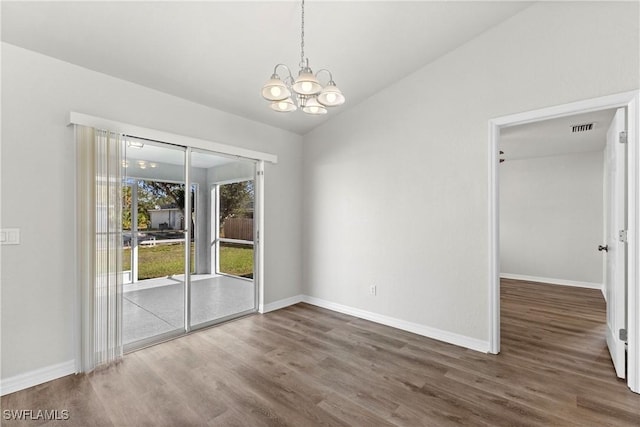 unfurnished dining area with visible vents, vaulted ceiling, wood finished floors, a chandelier, and baseboards