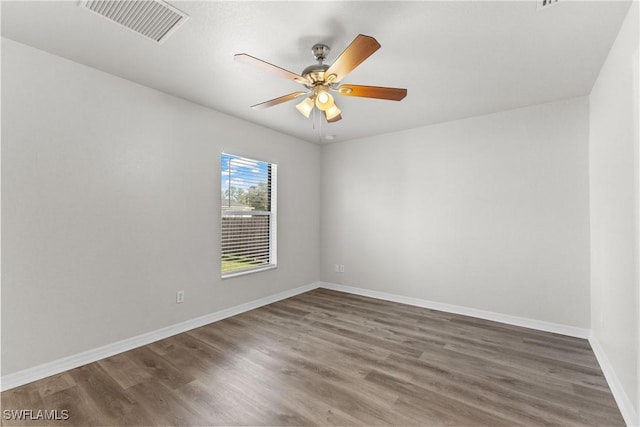 unfurnished room featuring wood finished floors, visible vents, and baseboards