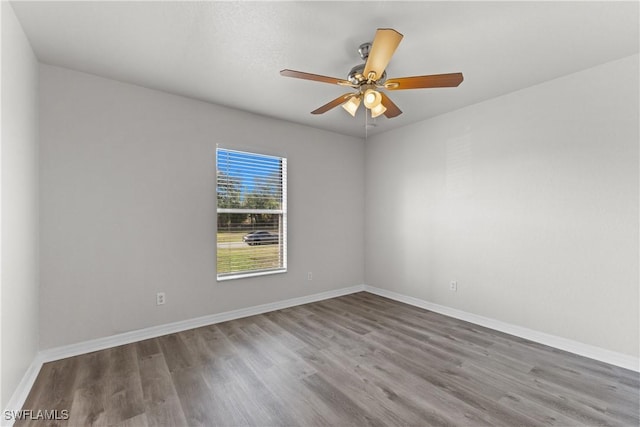 spare room featuring ceiling fan, baseboards, and wood finished floors