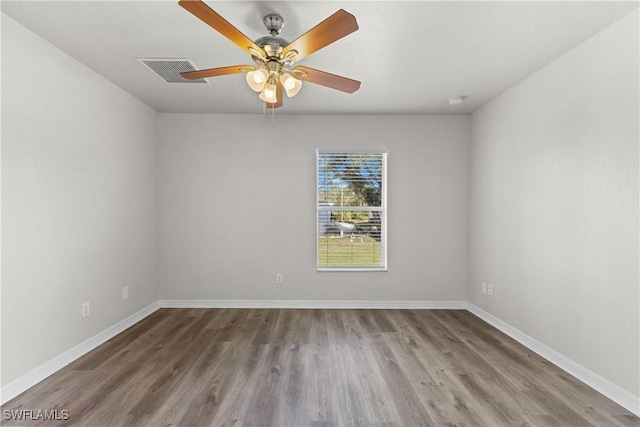 empty room featuring visible vents, ceiling fan, baseboards, and wood finished floors