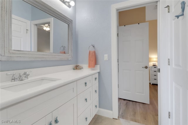 bathroom featuring baseboards, wood finished floors, and vanity