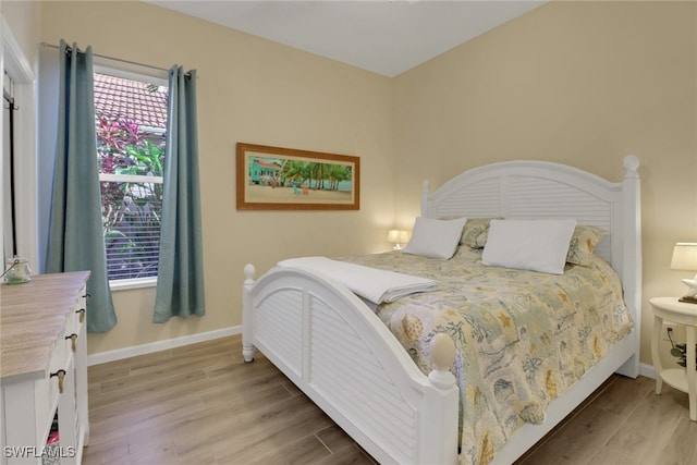 bedroom featuring baseboards and light wood-style floors