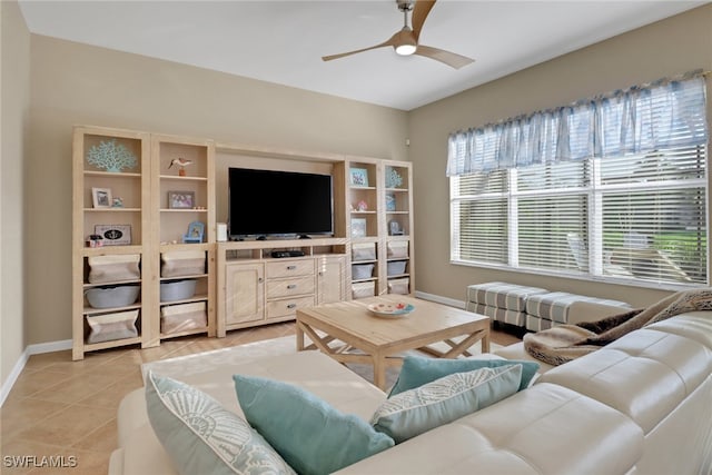 living area with a ceiling fan, light tile patterned flooring, and baseboards