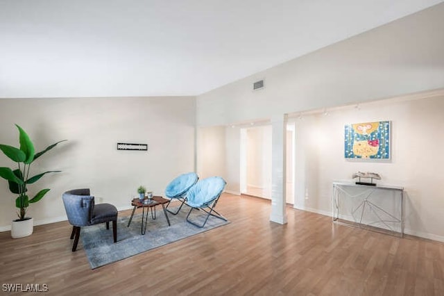 sitting room featuring wood-type flooring and vaulted ceiling