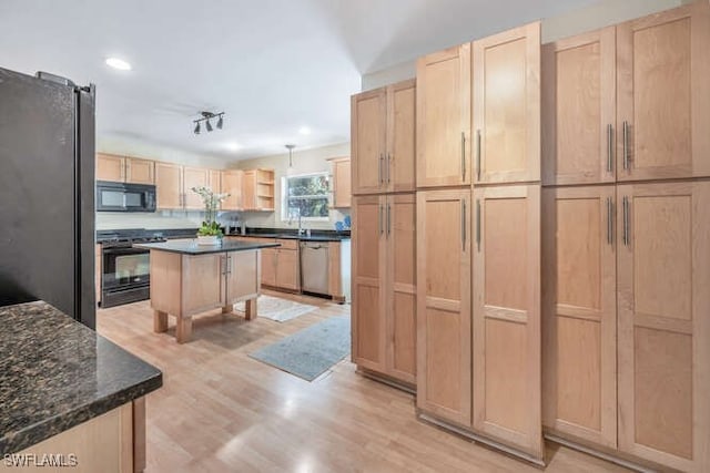 kitchen with dark stone countertops, a kitchen island, light brown cabinets, and black appliances