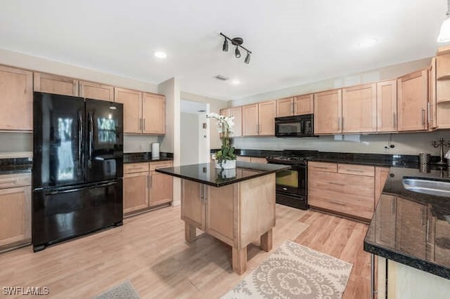 kitchen featuring light brown cabinetry, light hardwood / wood-style floors, a kitchen island, and black appliances