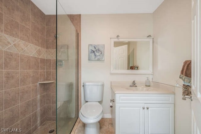 bathroom featuring a tile shower, vanity, tile patterned flooring, and toilet