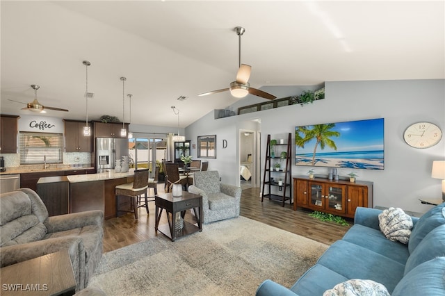 living room featuring vaulted ceiling, plenty of natural light, and wood finished floors