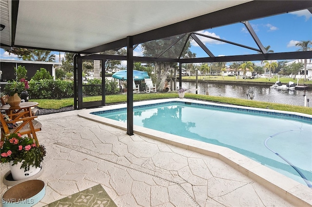 pool featuring a yard, a water view, a patio, and a lanai