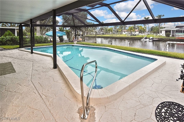 pool featuring glass enclosure, a patio, and a water view