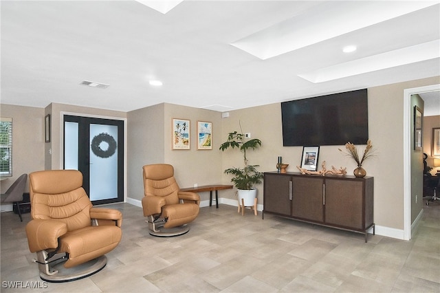 sitting room with a skylight, recessed lighting, baseboards, and visible vents