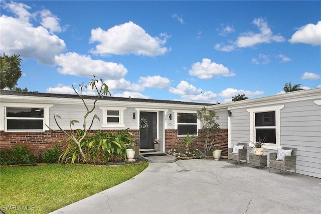 exterior space featuring brick siding and a front lawn