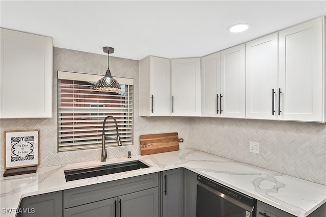 kitchen with tasteful backsplash, a sink, gray cabinets, and stainless steel dishwasher