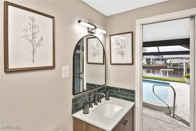 bathroom featuring decorative backsplash, a water view, and vanity