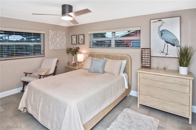 tiled bedroom featuring baseboards and a ceiling fan