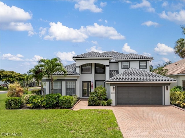 mediterranean / spanish home with a garage and a front yard