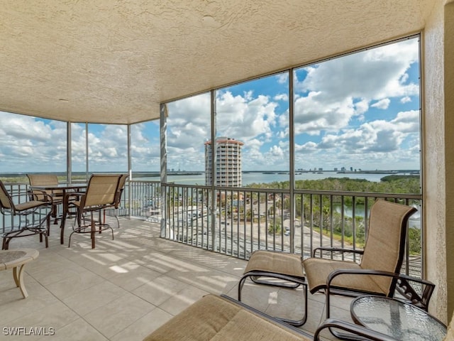 sunroom featuring a water view and plenty of natural light