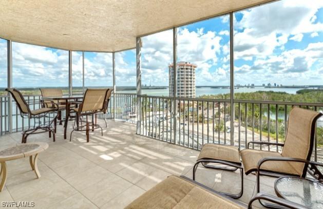 sunroom / solarium with a water view and a healthy amount of sunlight