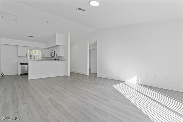 unfurnished living room featuring lofted ceiling and light wood-type flooring