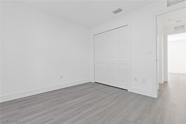 unfurnished bedroom featuring light hardwood / wood-style floors and a closet