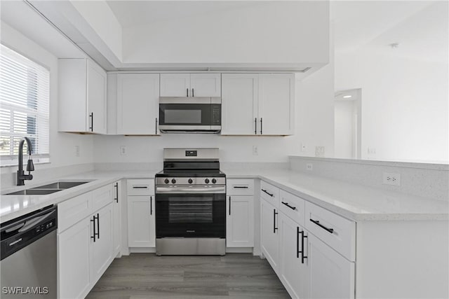 kitchen featuring white cabinetry, appliances with stainless steel finishes, sink, and hardwood / wood-style flooring