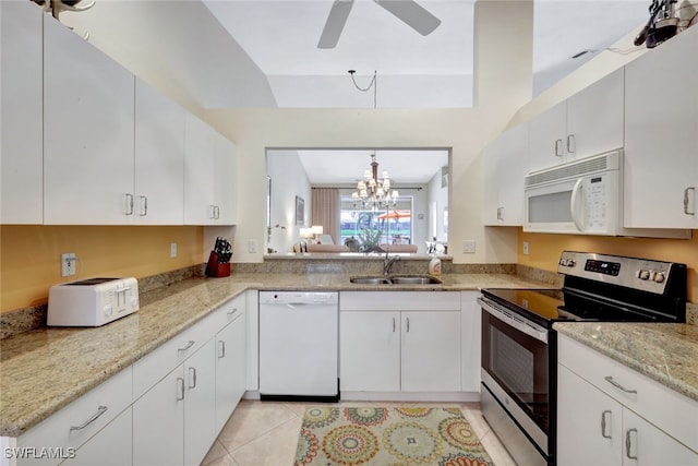 kitchen featuring light stone counters, sink, white appliances, and white cabinets