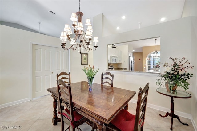 tiled dining room with an inviting chandelier and vaulted ceiling