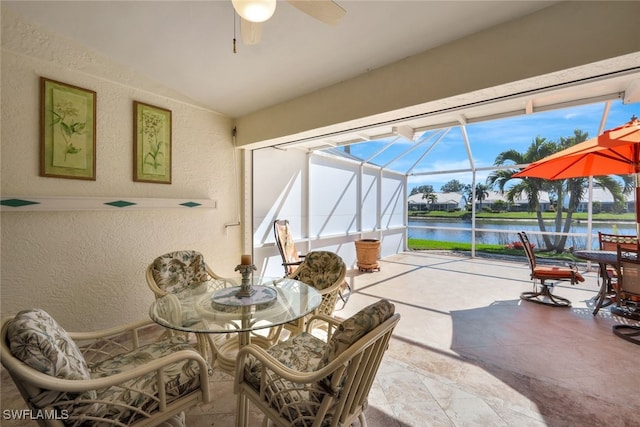 sunroom featuring vaulted ceiling, ceiling fan, and a water view