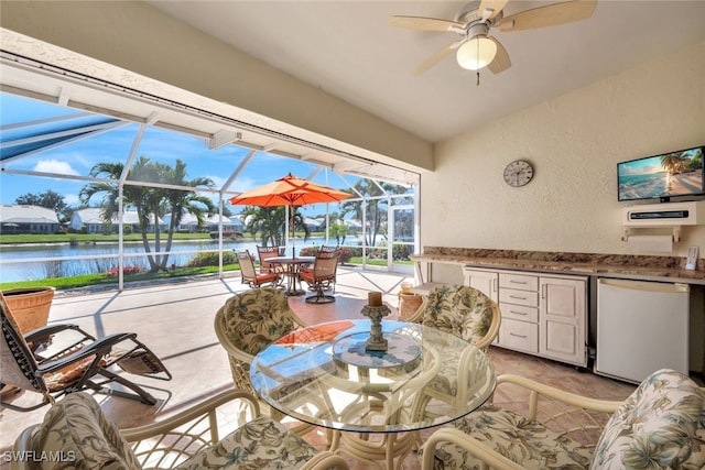 sunroom / solarium featuring a water view and ceiling fan