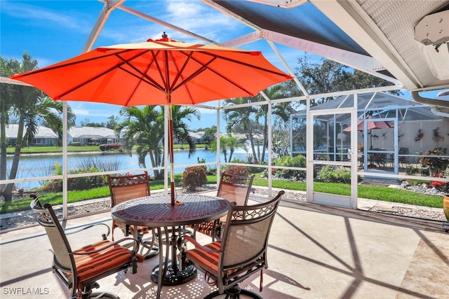 view of patio / terrace featuring glass enclosure and a water view