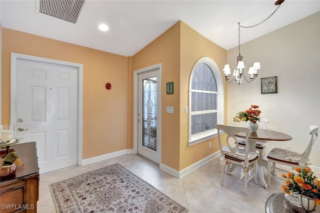 foyer featuring light tile patterned flooring and a chandelier