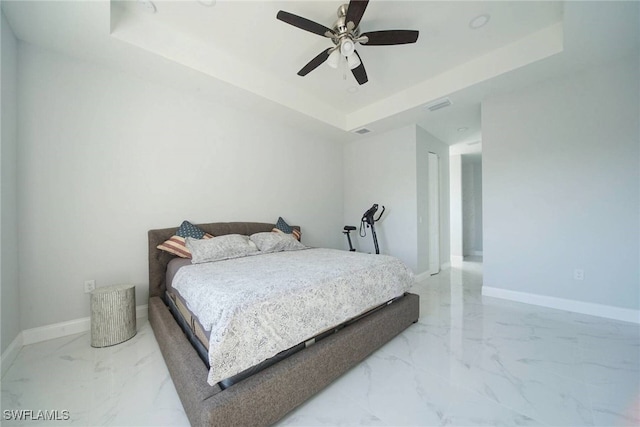 bedroom with a raised ceiling and ceiling fan