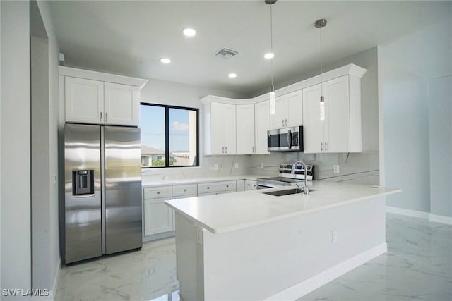 kitchen featuring pendant lighting, appliances with stainless steel finishes, kitchen peninsula, and white cabinets