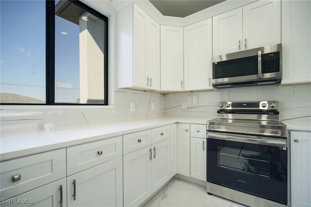 kitchen with white cabinetry, appliances with stainless steel finishes, and backsplash