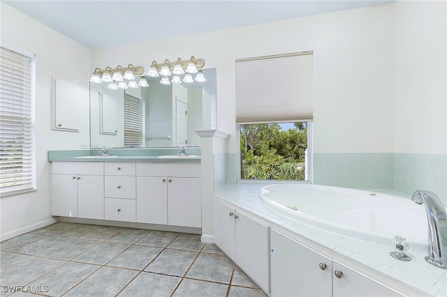 10800 Habitat Cir, Bokeelia, FL 33922 - bathroom featuring double vanity, a garden tub, baseboards, and tile patterned floors