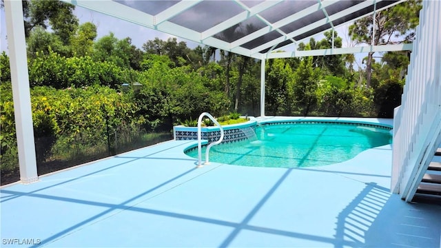 outdoor pool featuring a patio area and glass enclosure