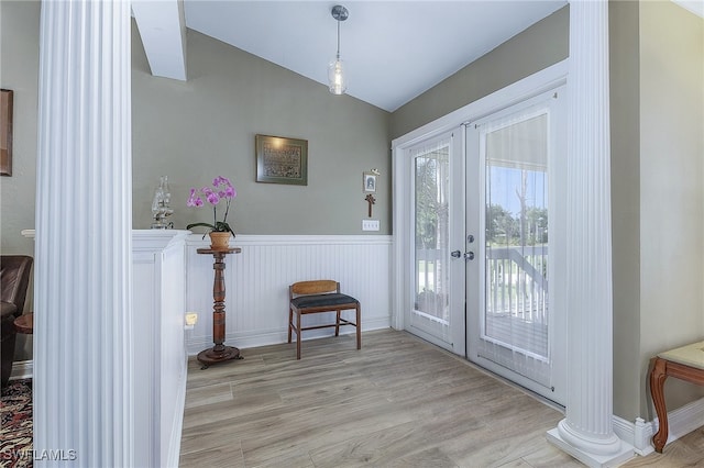 10800 Habitat Cir, Bokeelia, FL 33922 - doorway with vaulted ceiling, french doors, ornate columns, light wood-style floors, and wainscoting