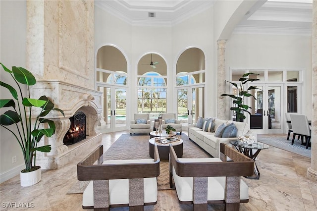 6511 Highcroft Dr, Naples, FL 34119 - living room with a high ceiling, ornamental molding, a fireplace, arched walkways, and french doors