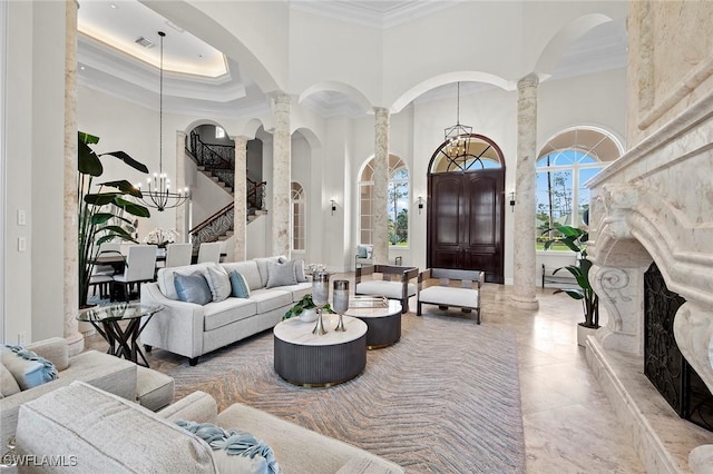 tiled living room featuring decorative columns, a high ceiling, a chandelier, and ornamental molding