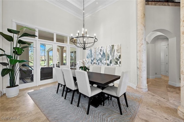 dining area with a high ceiling, ornamental molding, arched walkways, and a notable chandelier