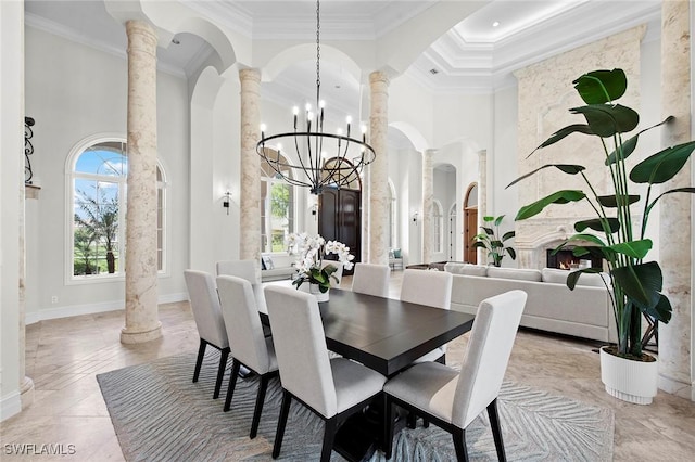 dining area featuring a healthy amount of sunlight, decorative columns, a high ceiling, and ornamental molding