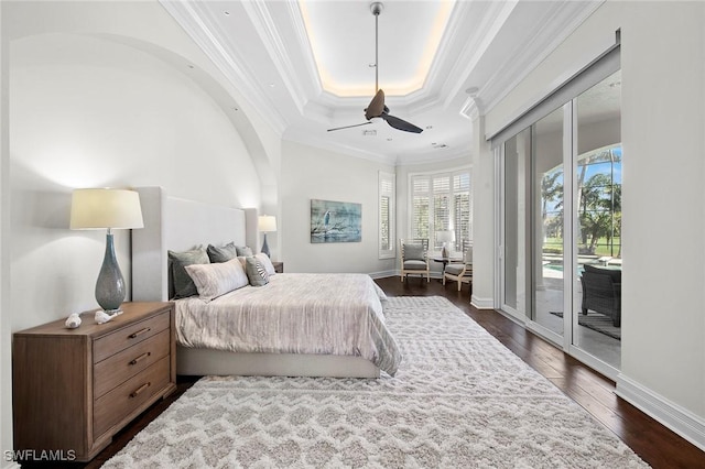 bedroom with baseboards, ornamental molding, dark wood-style flooring, access to exterior, and a tray ceiling