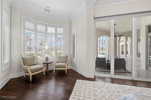 sitting room featuring visible vents, a wealth of natural light, hardwood / wood-style flooring, and crown molding