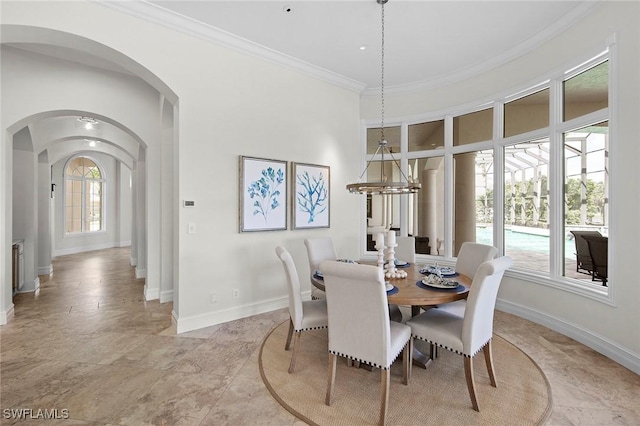 dining room featuring baseboards, an inviting chandelier, arched walkways, and crown molding