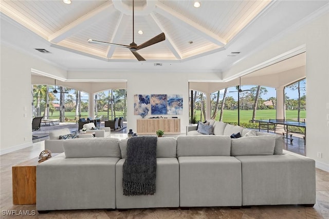 living area featuring ceiling fan, beamed ceiling, and plenty of natural light