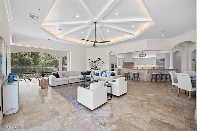 living area featuring arched walkways, beam ceiling, visible vents, ornamental molding, and coffered ceiling