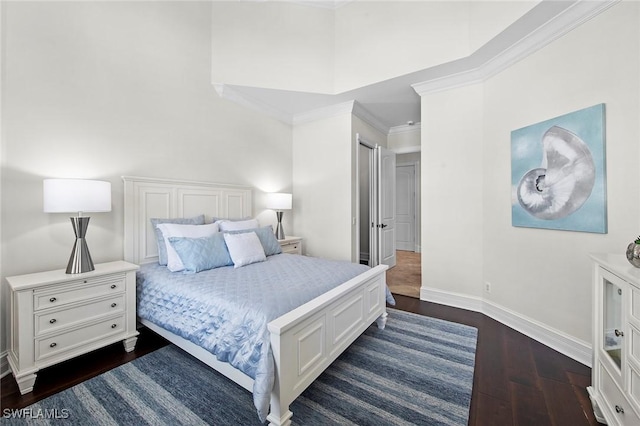 bedroom with baseboards, dark wood finished floors, and crown molding