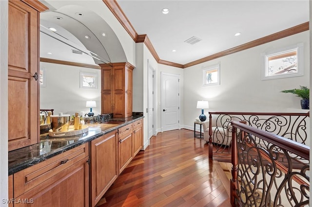 interior space featuring dark wood-type flooring, brown cabinets, visible vents, and a sink